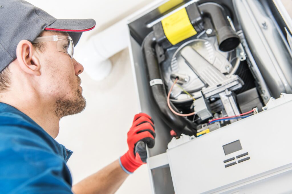 Technician inspecting a furnace unit, showcasing expertise in furnace repair services for Proactive Air Conditioning in Dallas, TX.