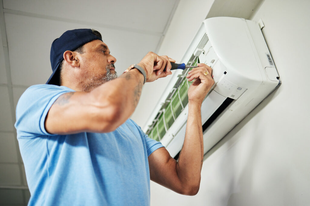 Technician repairing a ductless mini-split air conditioning unit, showcasing expertise in HVAC services relevant to Proactive Air Conditioning's offerings in Dallas, TX.