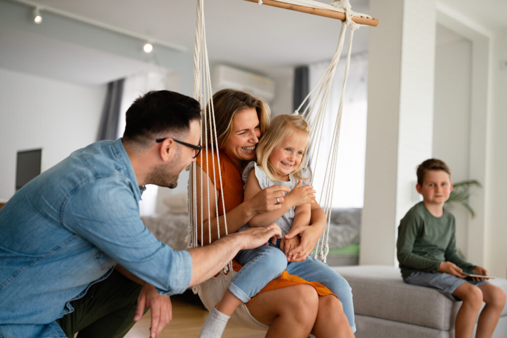 Happy family in Dallas, TX enjoying home comfort. Consider heat pump maintenance for a cozy home all year.