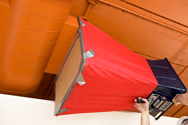 HVAC technician adjusting air balancing equipment in a commercial setting, emphasizing professional air conditioning services for efficient heating and cooling in Dallas.