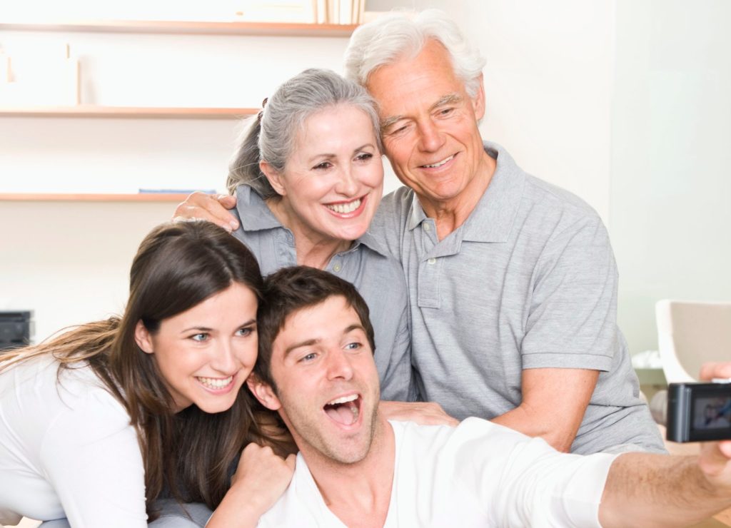 Family taking a selfie together, smiling and enjoying quality time, reflecting warmth and connection in a comfortable home setting.