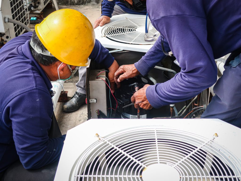Technicians performing HVAC maintenance on air conditioning units, emphasizing reliable service and expertise in Lakewood, Dallas, TX.