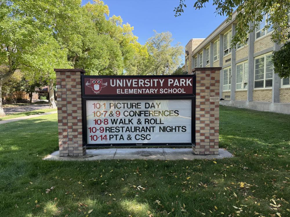 University Park Elementary School sign displaying upcoming events like Picture Day, Conferences, Walk & Roll, Restaurant Nights, PTA & CSC.