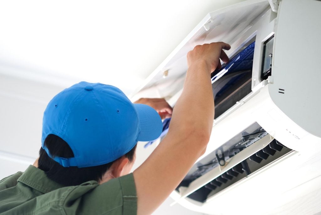 HVAC technician performing air conditioning maintenance, ensuring reliable cooling and efficiency for homes in Dallas, TX.