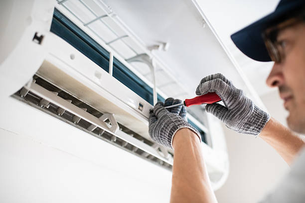 Technician repairing air conditioning unit indoors, showcasing emergency HVAC service expertise relevant to Proactive Air Conditioning's offerings in Dallas, TX.