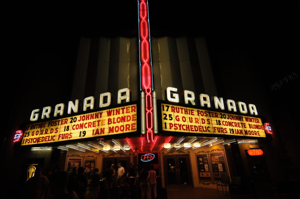 Lower Greenville's Granada Theater in Dallas, TX, aglow at night, showcasing upcoming performances; a vibrant hub for entertainment.